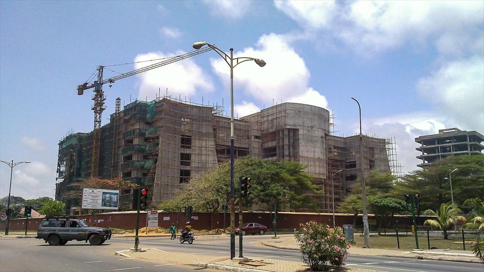 A busy road junction in North Ridge, Accra, with a building under construction and a tower crane