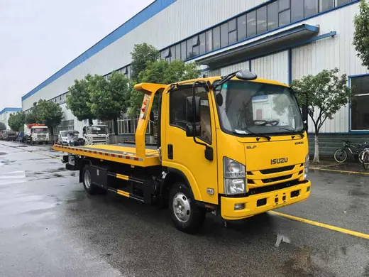 A yellow flatbed tow truck